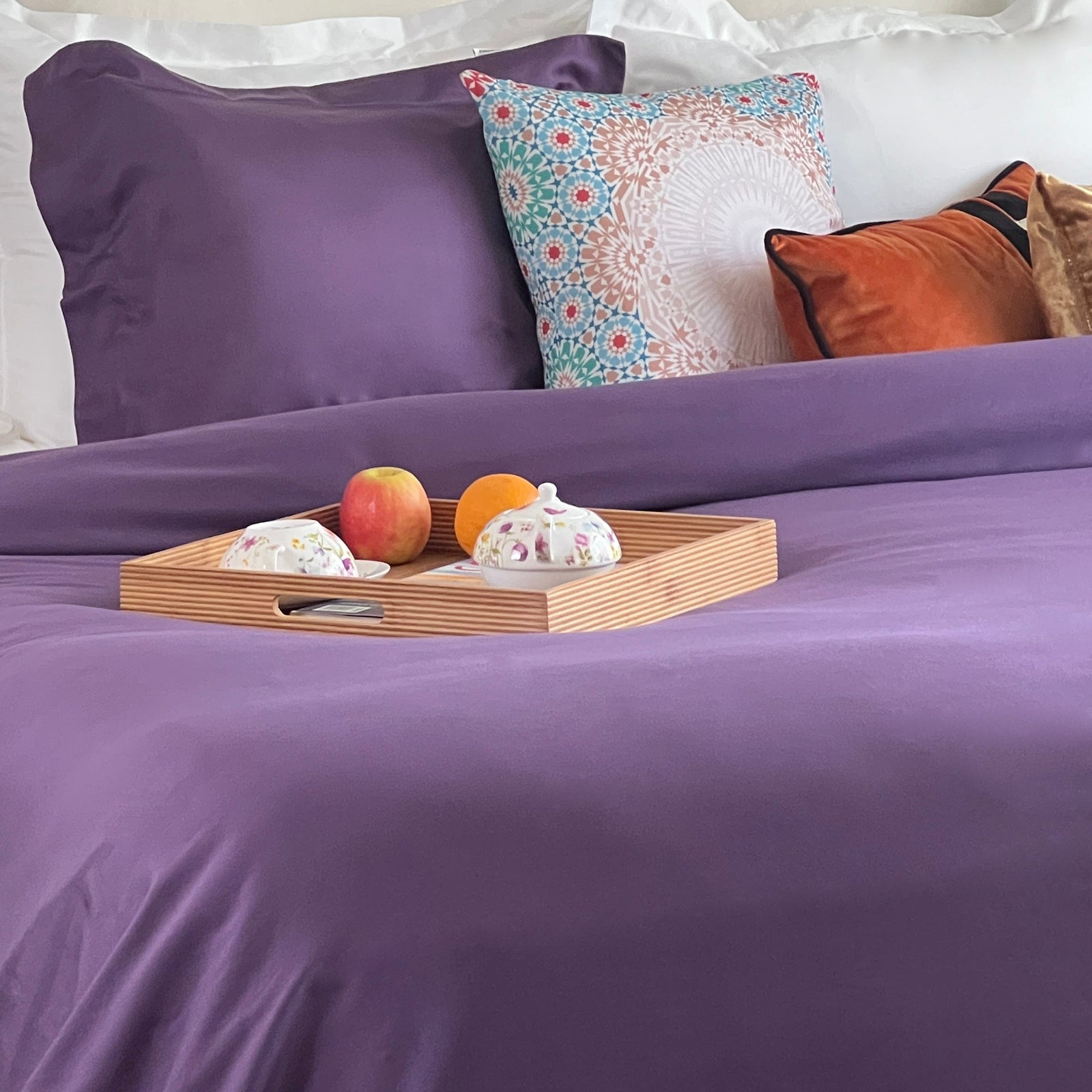 Purple duvet cover on a bed with a breakfast tray on top