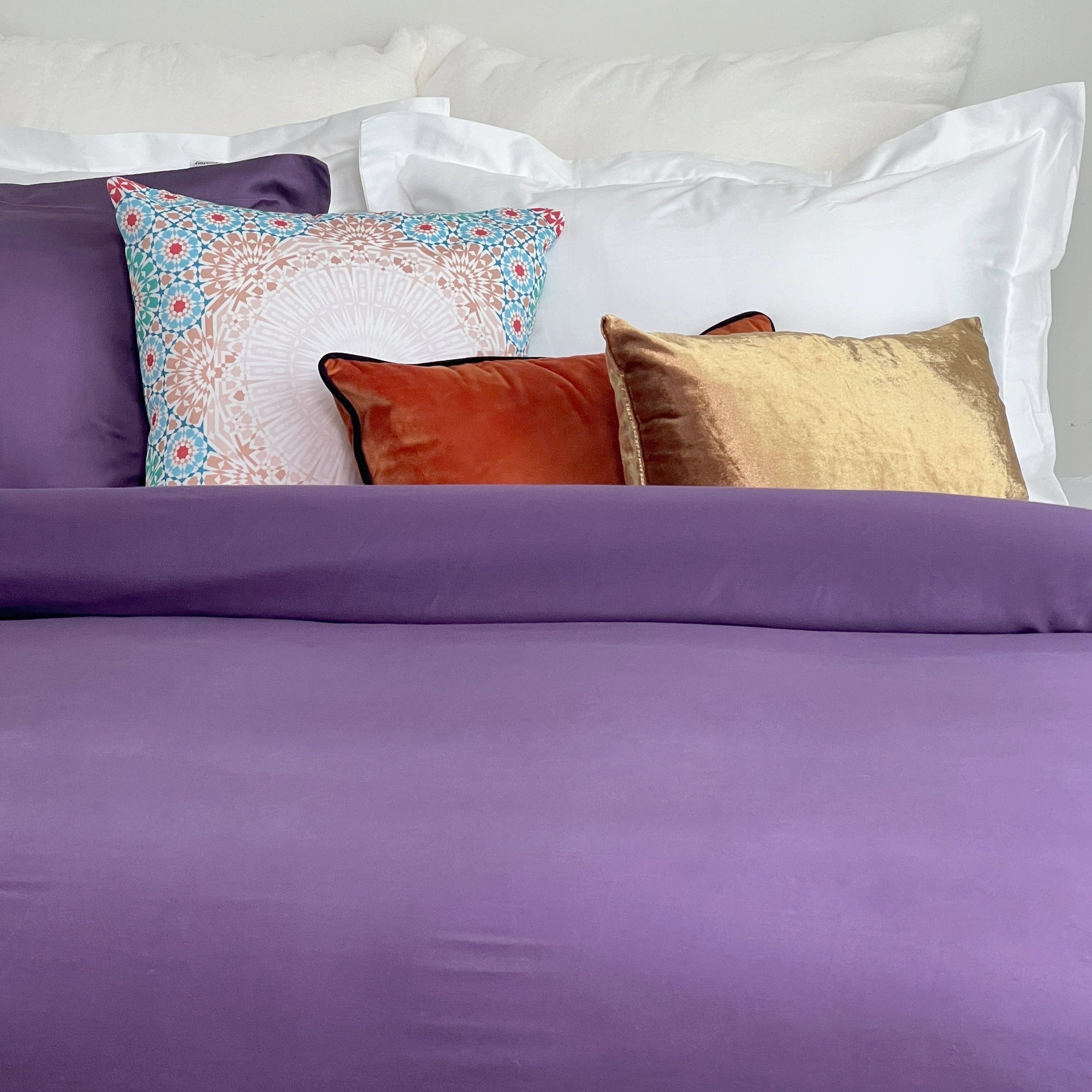 a bed made with a purple duvet cover