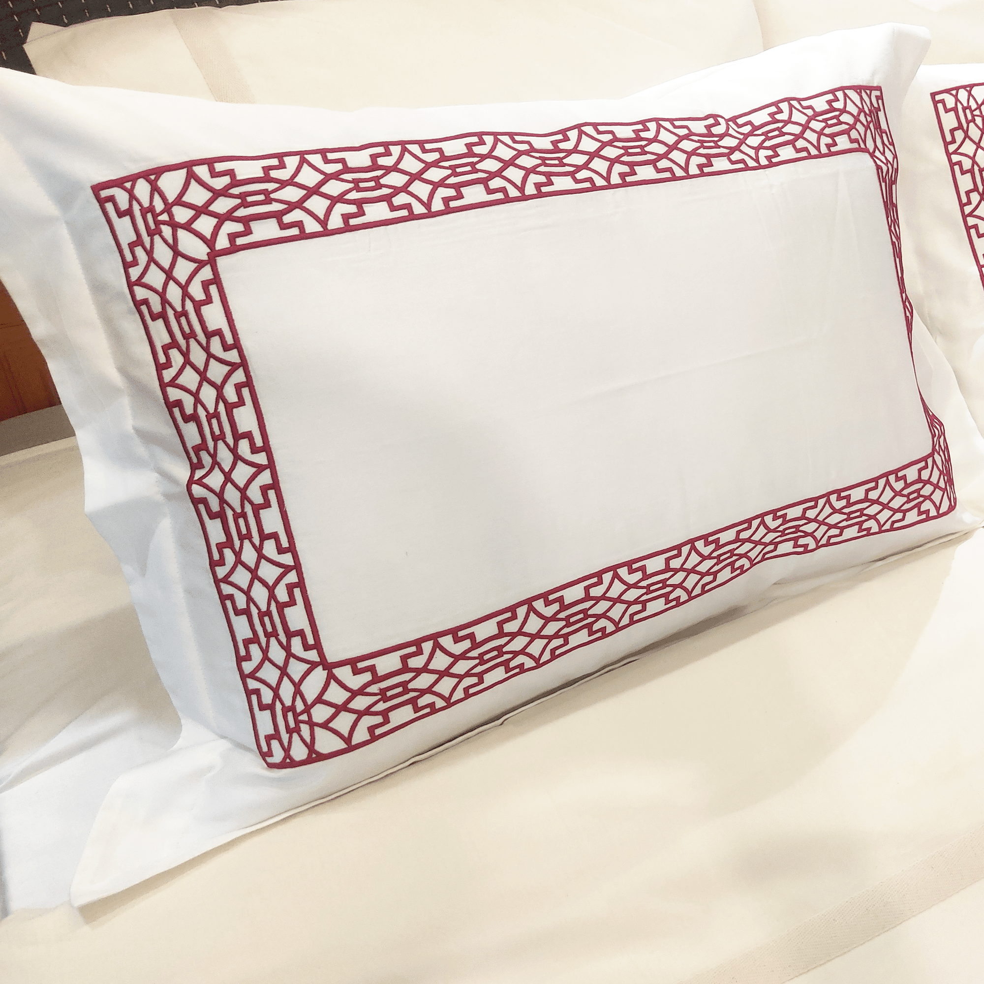 Experience luxury with sangria-colored embroidery on Beddley pillow shams